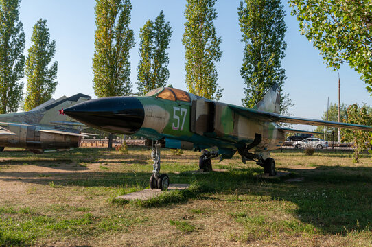 Fighter interceptor MIG 23. A combat aircraft standing on the ground in the Victory Park in Nizhny Novgorod. Standing against the backdrop of green trees and blue sky. High quality photo