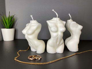 several beautiful female body shaped candle. silhouette of a female body with gold rings