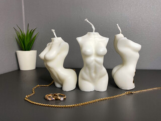 several beautiful female body shaped candle. silhouette of a female body with gold rings