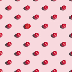 Seamless pattern with red tomatoes on a pink background.