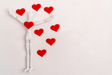 Wooden man mannequin with red heart white background. Valentines Day or International Day of Charity. Flat lay. Copy space