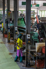 Fototapeta na wymiar Ceylon. Sri Lanka. Nuwara Eliya. Damro Tea Factory. Interior inside the workshop among the machines. Workers are working.