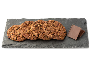 Pieces of chocolate bar and chocolate granola cookies on a stone board for serving.