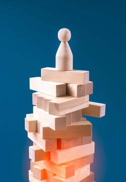 Precarious Business Situation Concept With Wooden Human Figurine Standing On Wooden Blocks. Vertical Background.