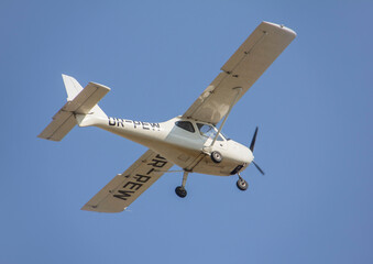 White plane takes off from the airport against the backdrop of a clear sky during the day