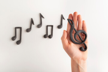 Violin key on the palm of your hand on notes background. Treble clef and notes on white background....