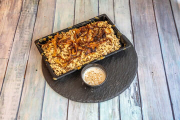 The mujaddara, known as mejadra, mudardara or myadra is a dish of lentils cooked together with wheat or rice, all decorated and accompanied with fried onions and olive oil.