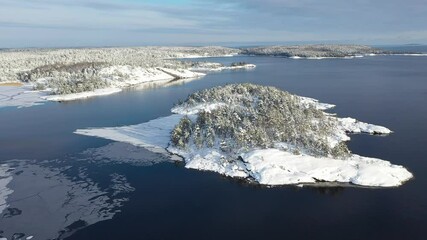 National Park Ladoga Skerries, in winter in Karelia Russia Small stone islands in snow on Lake Ladoga on a sunny day