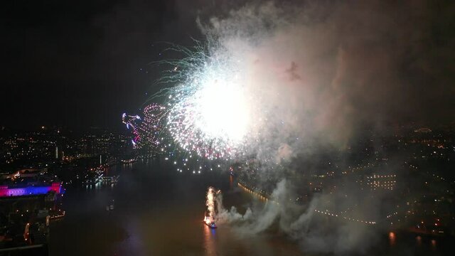 Aerial drone video of spectacular new year's eve celebration colourful and dazzling fireworks over river 