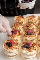 step by step preparation of sweet dessert with vanilla cream and cookies with cinnamon and red berries,