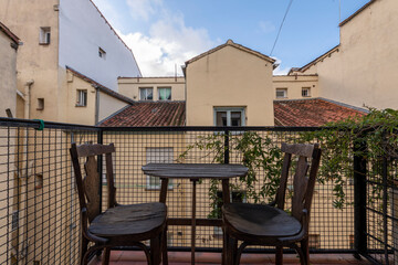 Small terrace with vines and a wooden table and chairs for relaxation