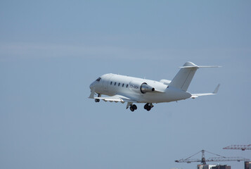 Fototapeta premium Private white jet plane takes off from the airport against the backdrop of a clear sky during the day