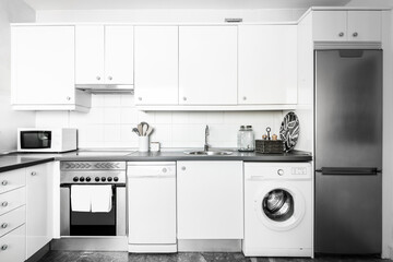 Kitchen with white cabinets and appliances in a vacation rental apartment