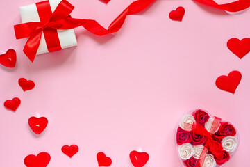 The concept of Valentine's Day, wedding, birthday. A box with roses, red hearts, a gift with a satin ribbon and candles on a pink background. Flat lay, copy space.