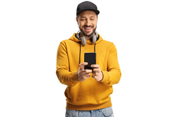 Smiling young man with headphones around neck and a cap using a smartphone and smiling