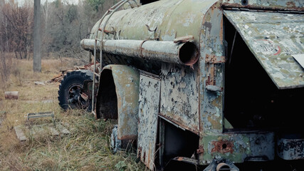 damaged and rusty military vehicle in forest in chernobyl exclusion zone.