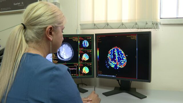 Yerevan, Armenia - September, 2021: In Medical Laboratory Patient Undergoes MRI or CT Scan Process under Supervision of Radiologist, in Control Room Doctor Watches Procedure in Monitors