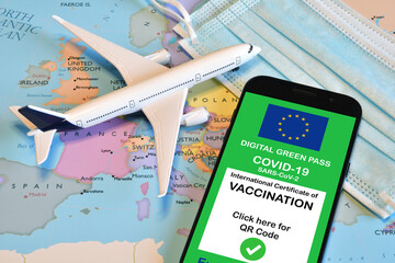 Fototapeta na wymiar Traveling during the corona virus pandemic. Smartphone with european digital covid-19 vaccination certificate along with protective masks and airplane model on european map. Safe travel concept.
