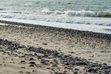 sandy sea shoreline with pebbles, selected focus