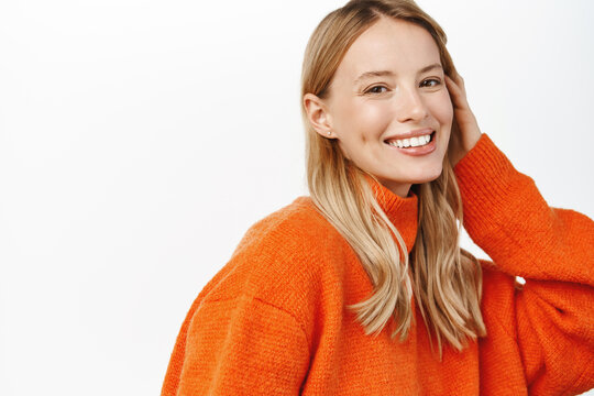 Beautiful Woman With Blond Natural Hair, No Makeup And Clean Glowing Face, White Smile, Posing In Red Winter Sweater, Looking At Camera Sensual, Standing Over White Background