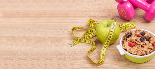 diet background with cereal bowl, apple with measuring tape and dumbbells - Powered by Adobe