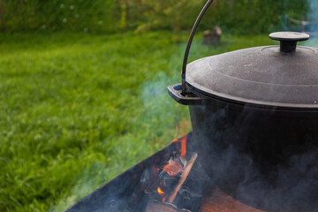 outdoor cooking in a pot, preparing food in a summer camp kitchen