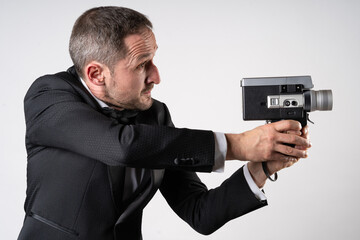 A parody of James Bond, a man wearing a tuxedo  handling a Super 8 camera in a classic 007 pose.