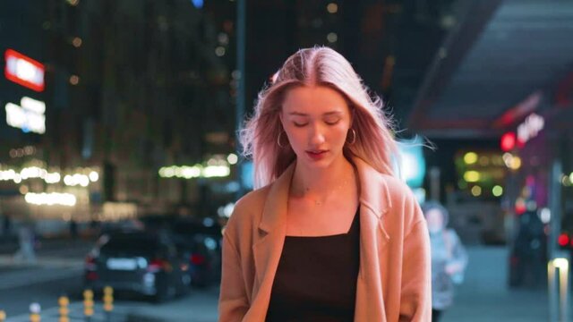 beautiful young girl blonde walks around the night city