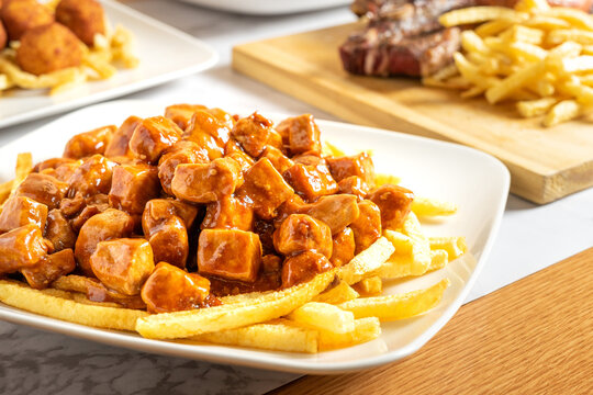 Raxo, traditional Galician dish, along with other dishes served at the same table. Traditional food from the northern region of Spain. 