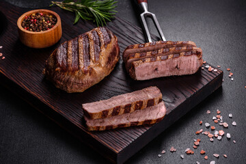 Fresh juicy delicious beef steak on a dark background