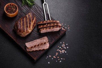 Fresh juicy delicious beef steak on a dark background