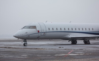Private jet airliner parked at the airport in cloudy weather