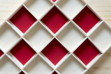 wooden box with square spaces and red paper squares