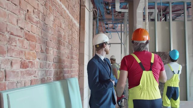 Foreman and contractor walking at construction site. Realtime
