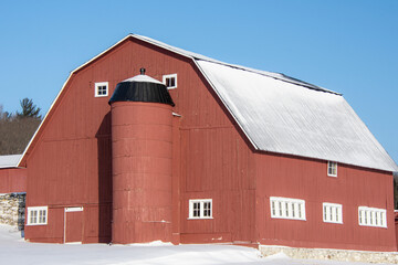 Fototapeta na wymiar Old barn in a winter countryside landscape in Quebec, Canada