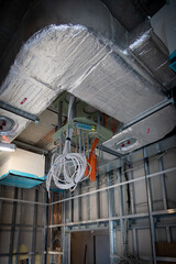 In a new operating theater building, cables hang from the ceiling and air-conditioning ducts run