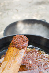 Nigerian stew on a a wooden spoon