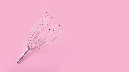 Manual head and neck massager isolated on pink background. Home use acupuncture point head scalp octopus massager