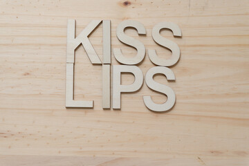 "kiss lips" in wood type isolated on a wooden surface