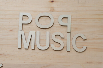 "pop music" in wood type isolated on a wooden surface
