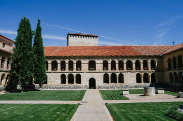 Fototapeta premium Front view of the courtyard of the Santo Domingo convent in Caleruega with two large cypress trees, Burgos, Castilla y León, Spain.