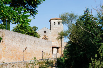 Fototapeta na wymiar Collegiate Church of San Cosme and San Damián in covarrubias seen from the river and its wall, Burgos, Castilla y León, Spain.