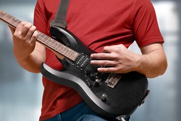 Lifestyle concept. Young musician playing guitar in the living room at home on this weekend.