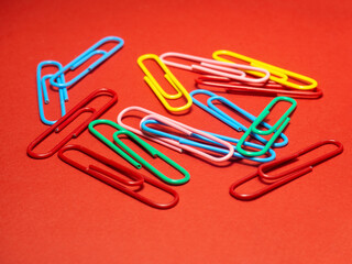 Colored paper clips on paper. Office supplies. Business goods.