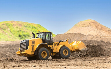Fototapeta premium Yellow wheel loader on the road construction site