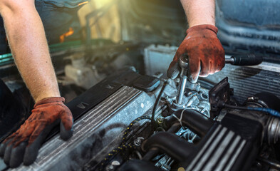 car engine repair, car mechanic tightening valve cover bolts.