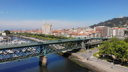 Obraz premium The Gustave Eiffel Bridge over the river Lima in Viana do Castelo. Aerial panoramic cityscape view of Viana and the Marina.