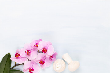 Fototapeta na wymiar Sea salt, aromatherapy oil in bottles and orchid on vintage wooden background.