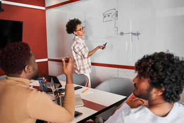 Female designer or blogger creating something while standing near the board