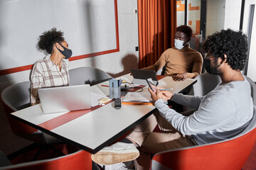 Two college students or young colleagues discussing work in coworking room